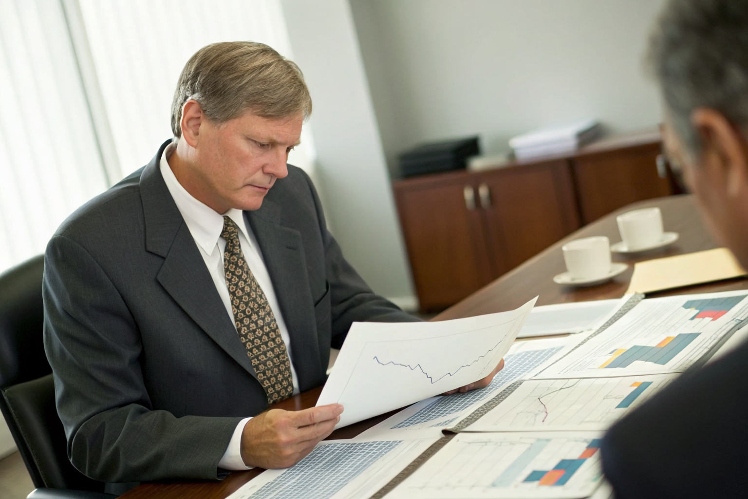 Office with administrator reviewing technical documents and detailed charts.