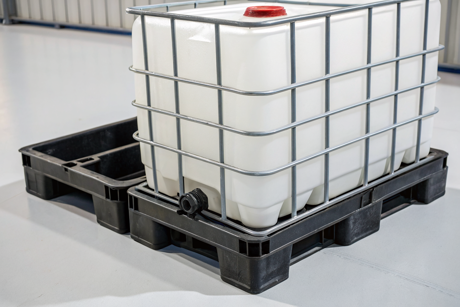 Rigid polyethylene IBC pallet with spill containment sump.