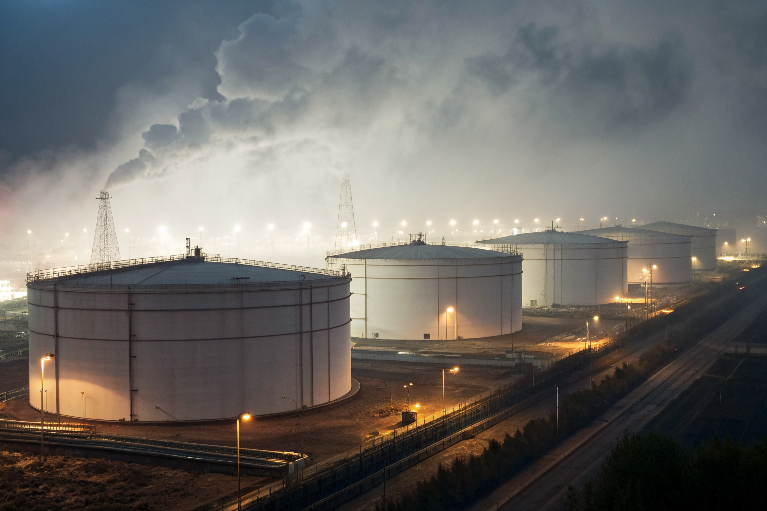 Oil storage facility with containment structures, dramatic lighting.