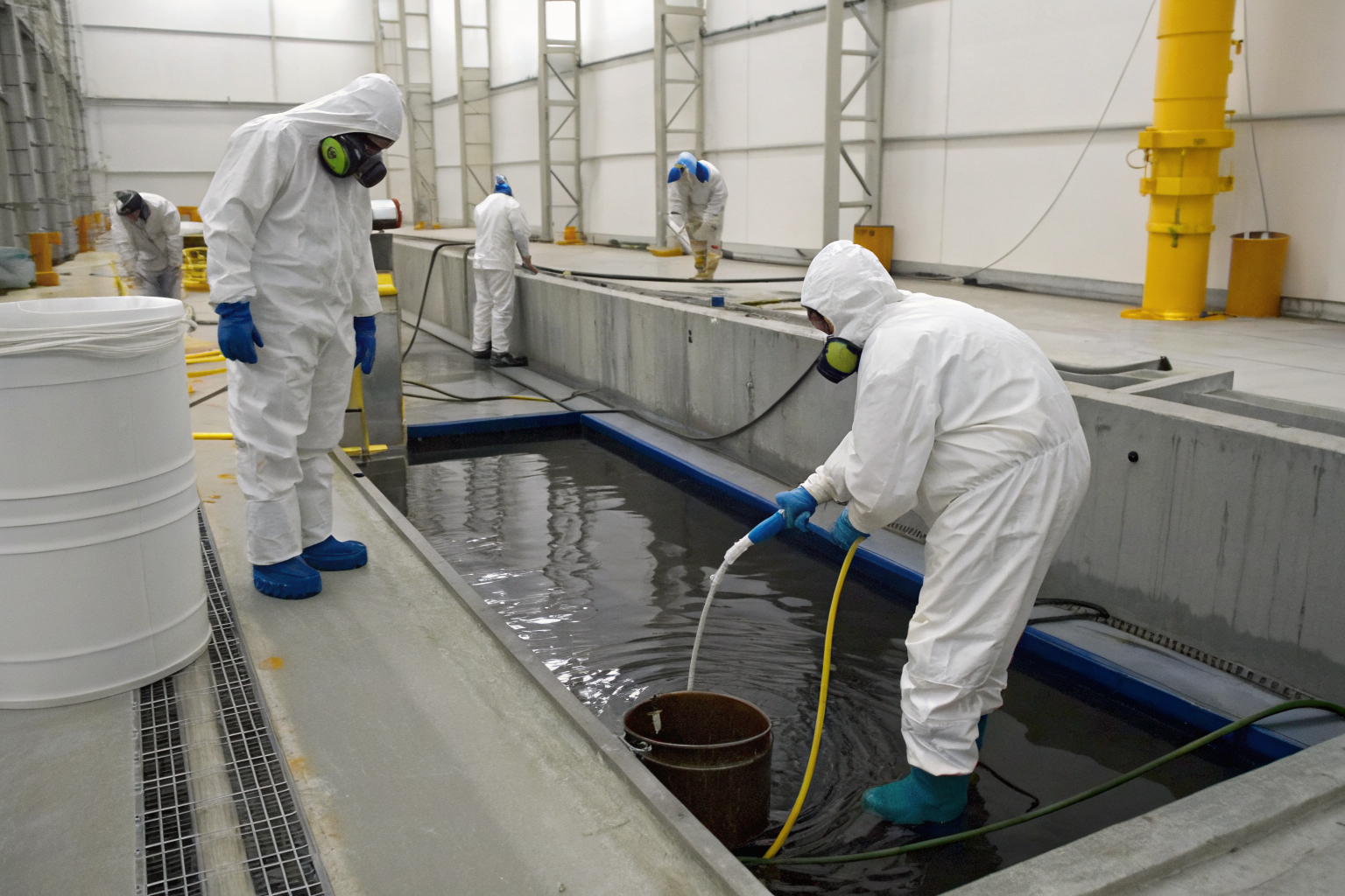 Containment area with clean water for hydrostatic testing, technicians present.
