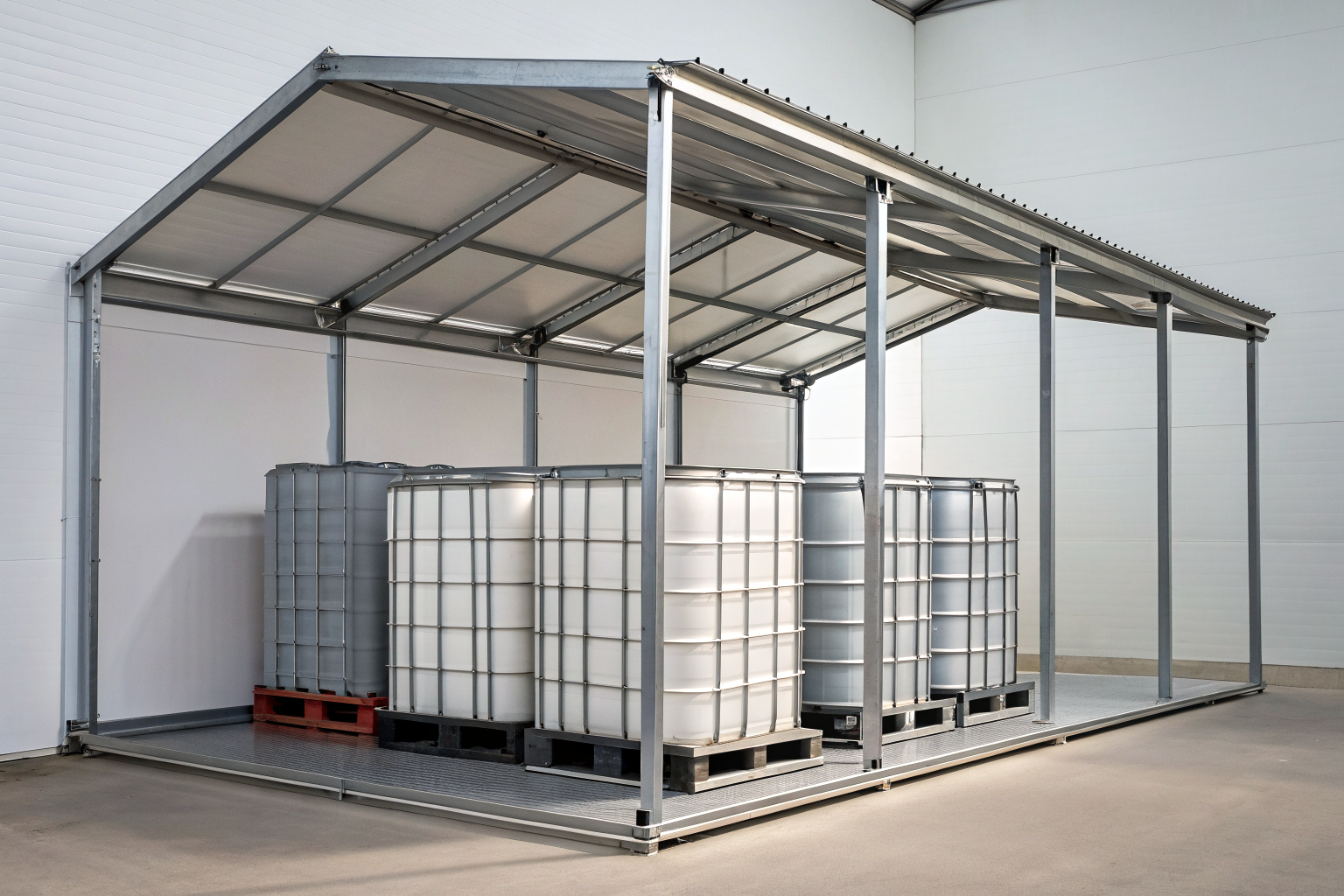 Steel frame IBC shelter with totes inside in industrial setting.