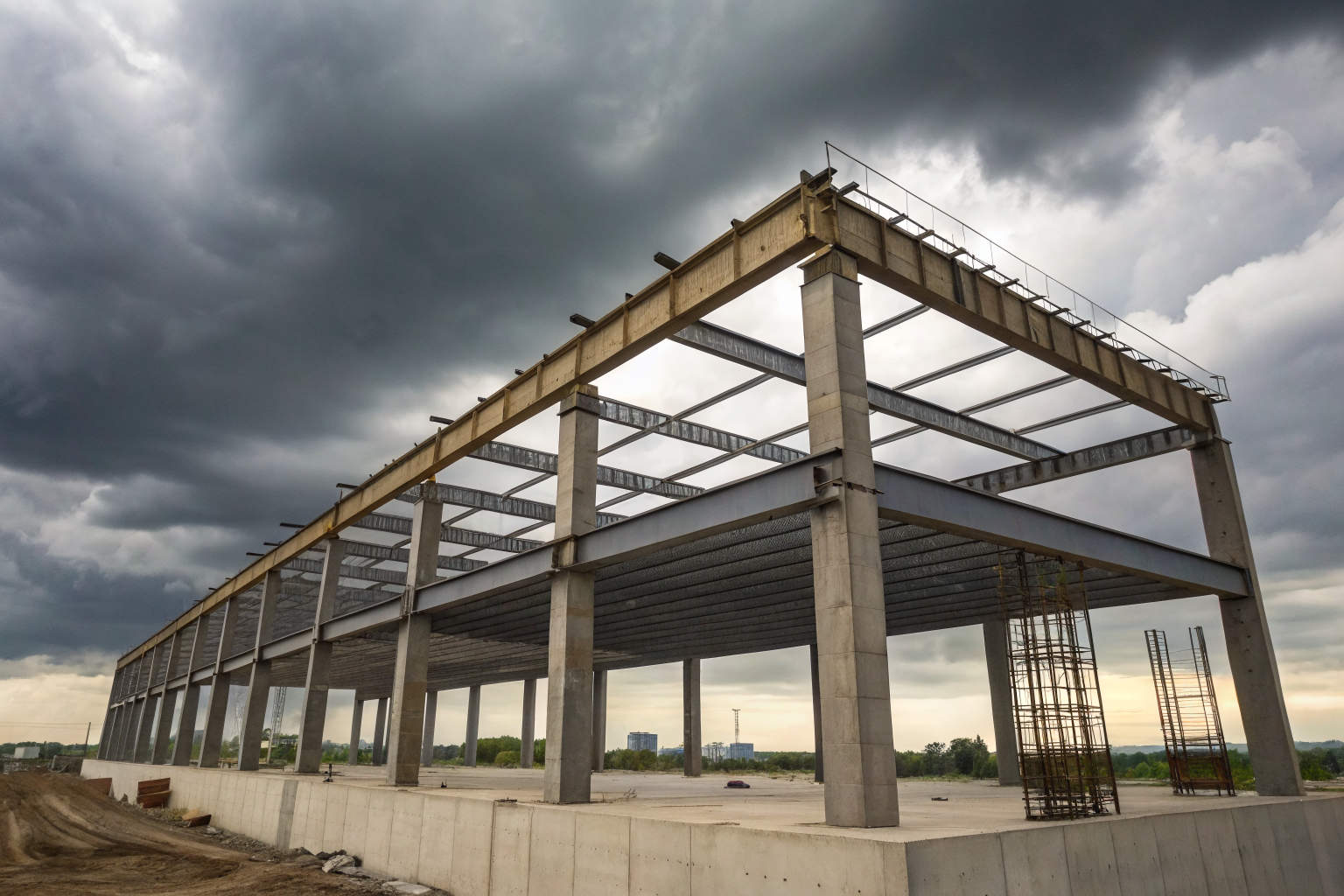 Containment structure with steel beams and concrete under cloudy sky.