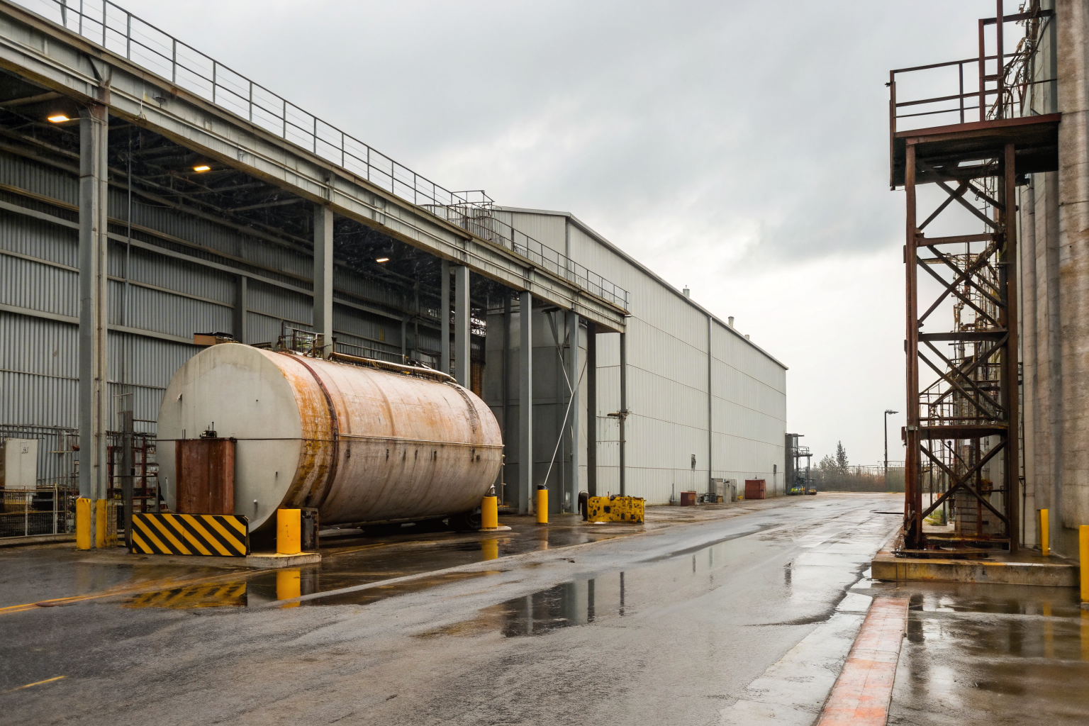 Industrial tank facility with 'Temporarily Closed' sign and barriers.