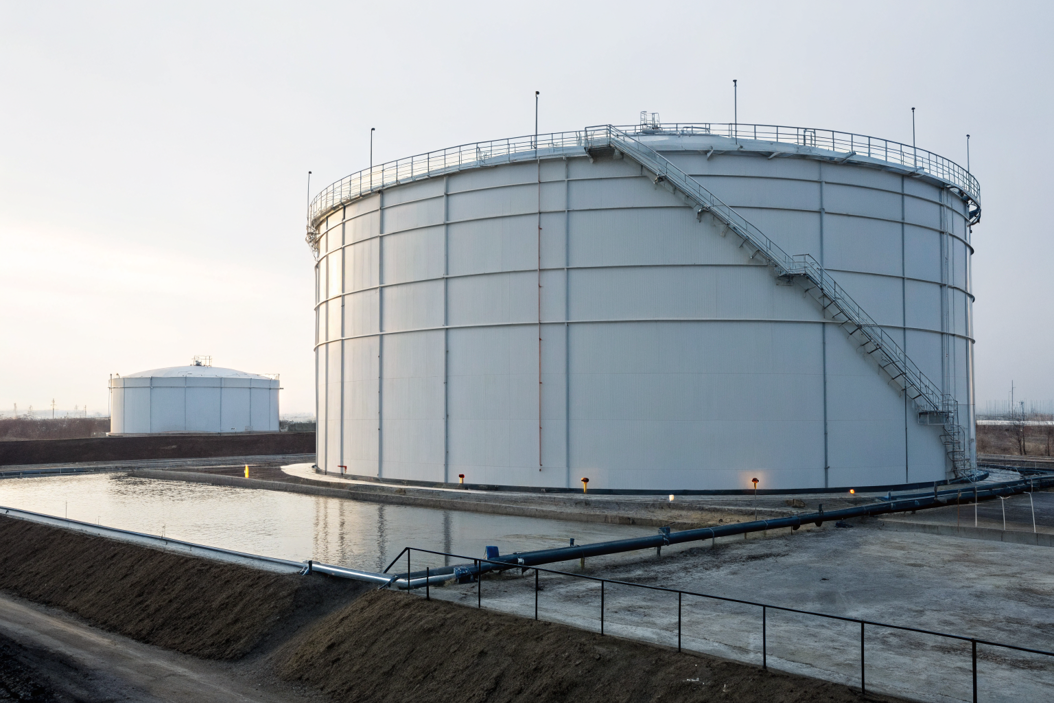Storage tank and containment area under clear sky, showing capacity design.